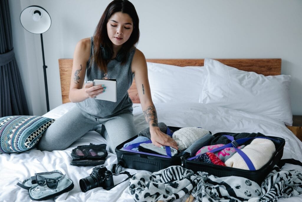 woman packing luggage on the bed