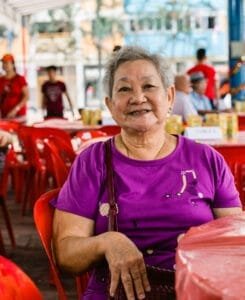 lady-seating-on-red-chair-smiling-at-camera